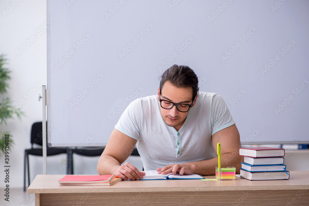 Young male teacher student sitting in the classroom Young male teacher student sitting in the classroom