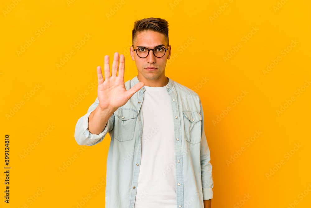 Young handsome caucasian man isolated standing with outstretched hand showing stop sign, preventing you. Young handsome caucasian man isolated standing with outstretched hand showing stop sign, preventing you.