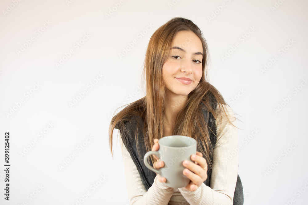 Portrait photo of nice cute girl holding cup of coffee showing at empty space smiling isolated on white color background Portrait photo of nice cute girl holding cup of coffee showing at empty space smiling isolated on white color background
