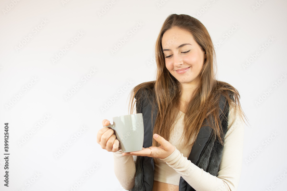 Portrait photo of nice cute girl holding cup of coffee showing at empty space smiling isolated on white color background Portrait photo of nice cute girl holding cup of coffee showing at empty space smiling isolated on white color background