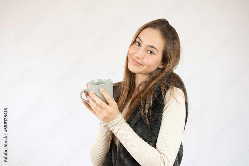 Portrait photo of nice cute girl holding cup of coffee showing at empty space smiling isolated on white color background Portrait photo of nice cute girl holding cup of coffee showing at empty space smiling isolated on white color background