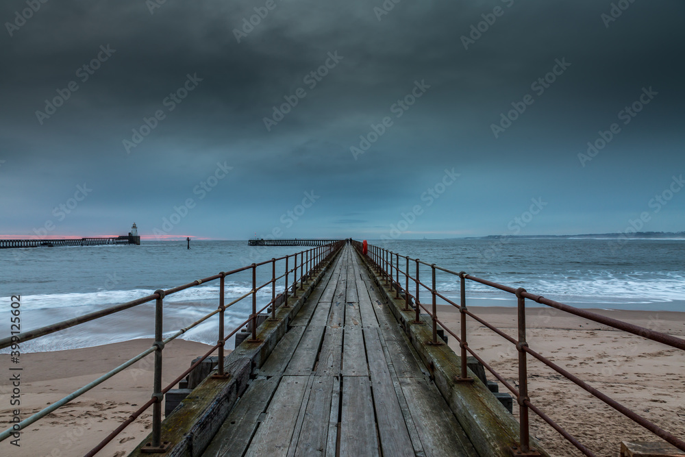 Morning at Blyth beach in Northumberland, England, with the old wooden Pier stretching out to the North Sea Morning at Blyth beach in Northumberland, England, with the old wooden Pier stretching out to the North Sea