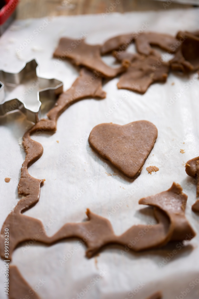 Raw rolled gingerbread dough, cutting festive shaped cookies Raw rolled gingerbread dough, cutting festive shaped cookies