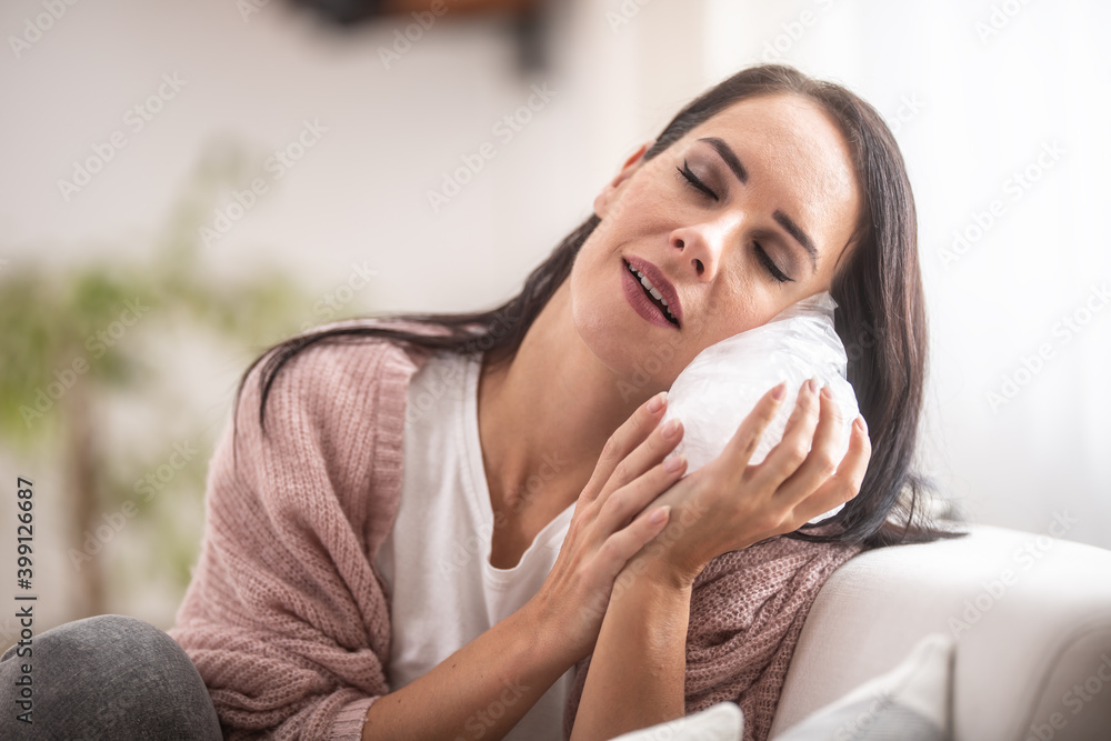 Face relief expression of a young woman holding ice bag on her cheek Face relief expression of a young woman holding ice bag on her cheek