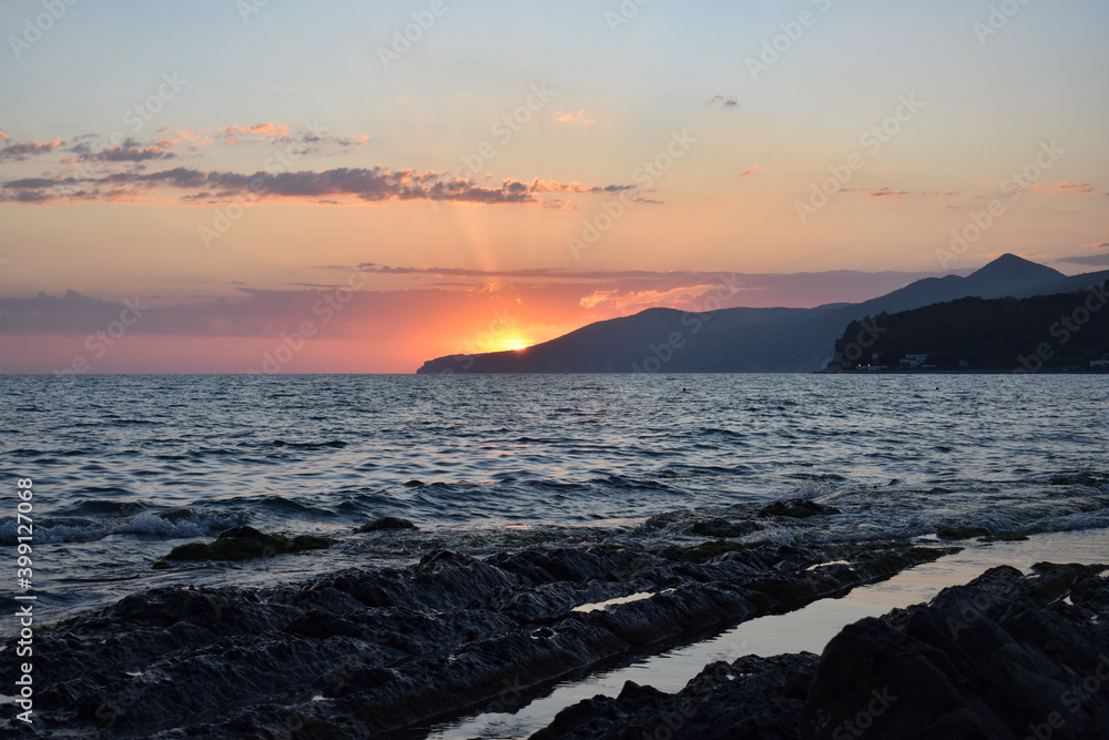 Fototapeta premium Red sunset on the sea.Stone beach