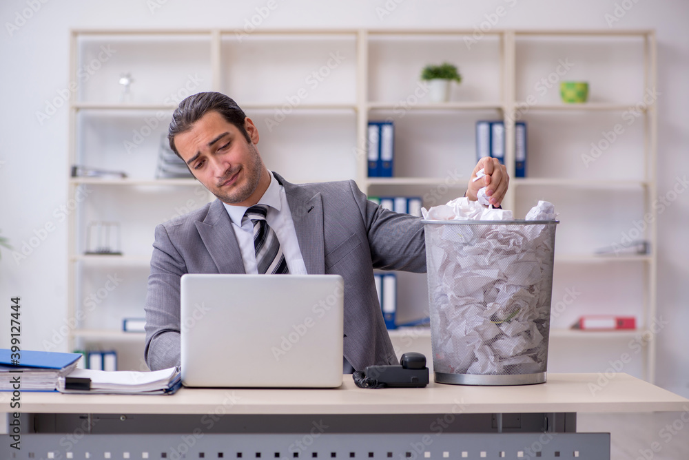Young businessman rejecting new ideas with lots of papers Young businessman rejecting new ideas with lots of papers