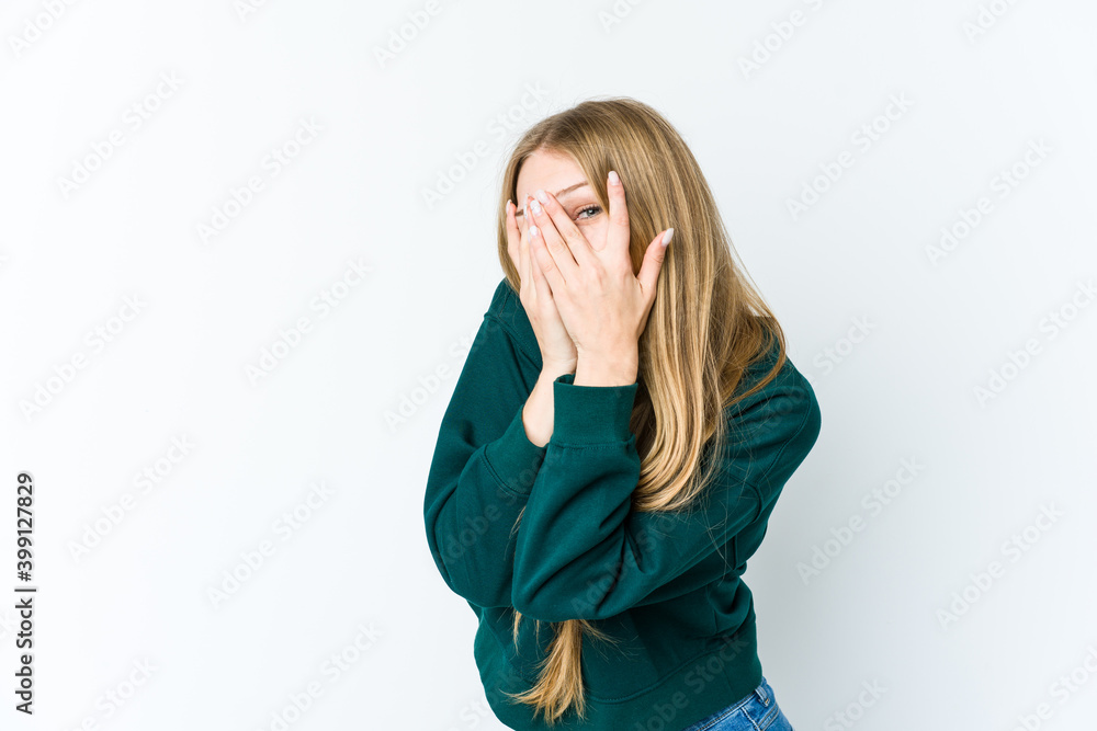 Young blonde woman isolated on white background blink through fingers frightened and nervous. Young blonde woman isolated on white background blink through fingers frightened and nervous.