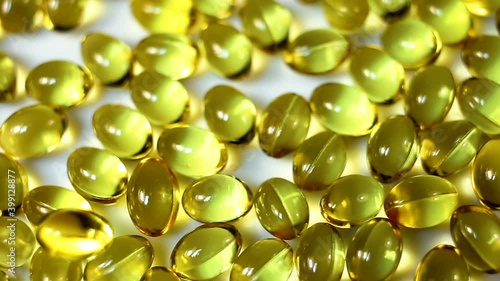 small oval transparent gel capsules have a yellow oily liquid inside. Dietary supplements, fish oil, cholecalciferol, close-up, real time