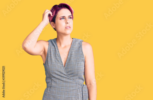 Young beautiful woman with pink hair wearing casual clothes confuse and wondering about question. uncertain with doubt, thinking with hand on head. pensive concept.