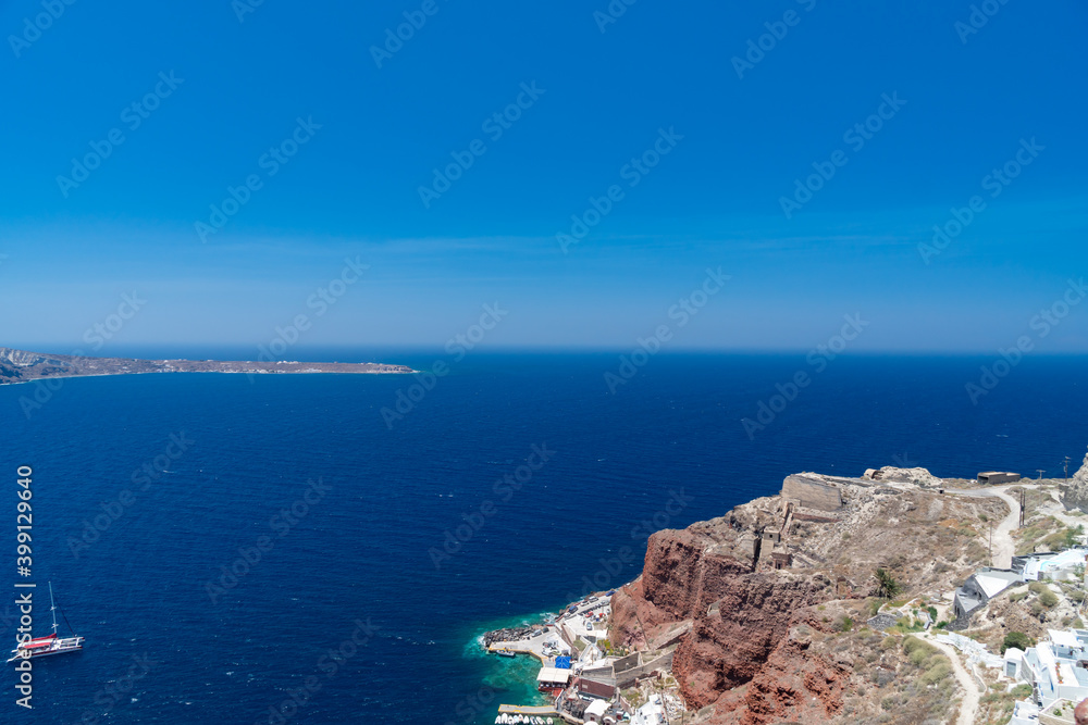 Panoramic view from white building, blue sky and vivid sea, cliffs in Santorini island, Oia, Greece.  