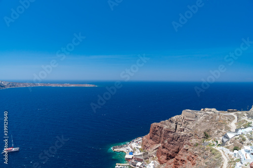 Panoramic view from white building, blue sky and vivid sea, cliffs in Santorini island, Oia, Greece. 