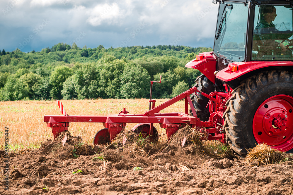 Obraz premium Farmer in tractor preparing land for sowing, plowing the field