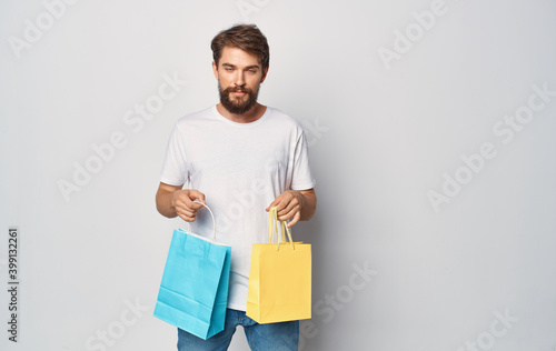 man in white t-shirt and jeans with packages in hands fun shopping joy isolated foil