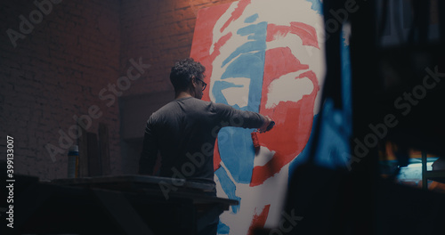 Man painting portrait with roller