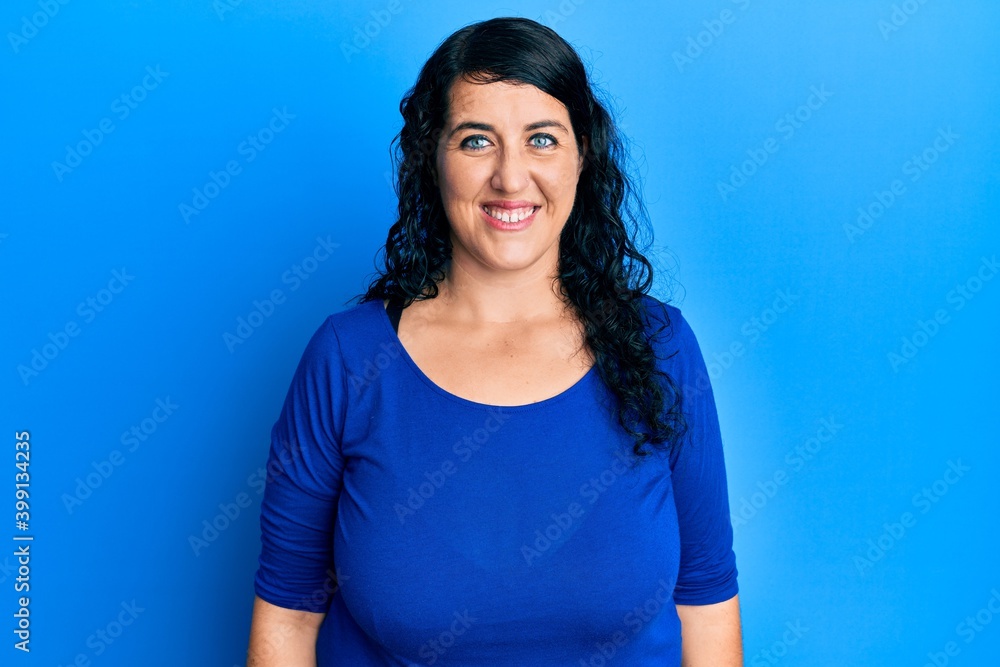 Plus size brunette woman wearing casual blue shirt with a happy and cool smile on face. lucky person. Plus size brunette woman wearing casual blue shirt with a happy and cool smile on face. lucky person.