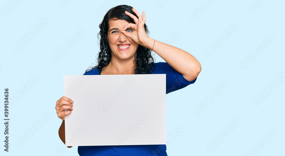 Plus size brunette woman holding blank empty banner with open hand doing stop sign with serious and confident expression, defense gesture Plus size brunette woman holding blank empty banner with open hand doing stop sign with serious and confident expression, defense gesture