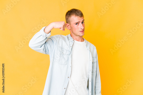Young caucasian handsome man person pointing by hand to a shirt copy space  proud and confident