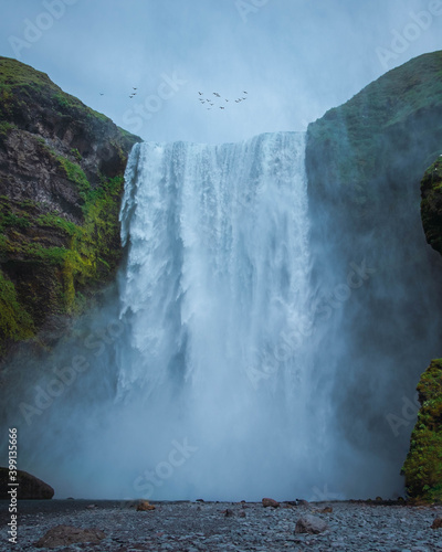 Huge waterfall in Iceland with a lot of water and some birds