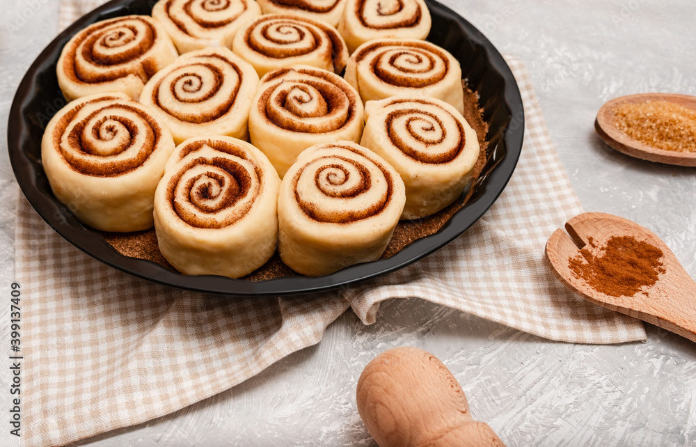 Raw cinnabon buns with cinnamon on ultimate grey backdrop. Ingredients and recipe. Christmas bakery. Flatlay. Kitchen appliances.