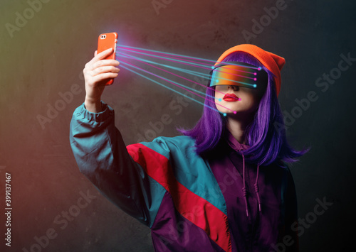 style hacker woman in VR glasses is with mobile phone