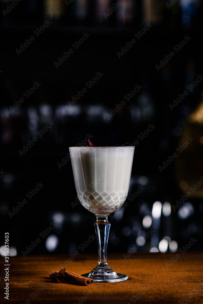 Closeup glass of eggnog cocktail decorated at bar counter background, white cocktail on a bar background Closeup glass of eggnog cocktail decorated at bar counter background, white cocktail on a bar background