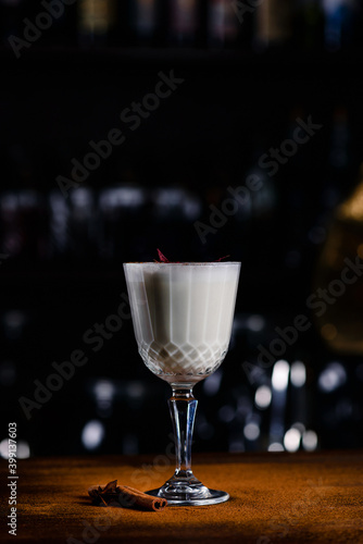 Closeup glass of eggnog cocktail decorated at bar counter background, white cocktail on a bar background