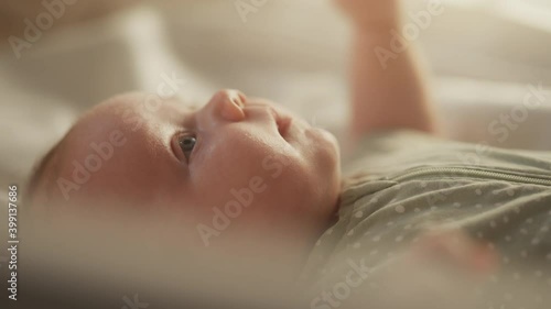 Authentic Close Up Footage of a Cute Newborn Baby Lying on the Back in Child Crib photo