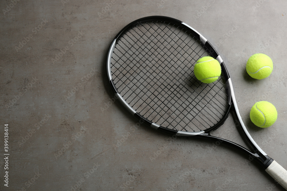 Tennis racket and balls on grey table, flat lay. Space for text