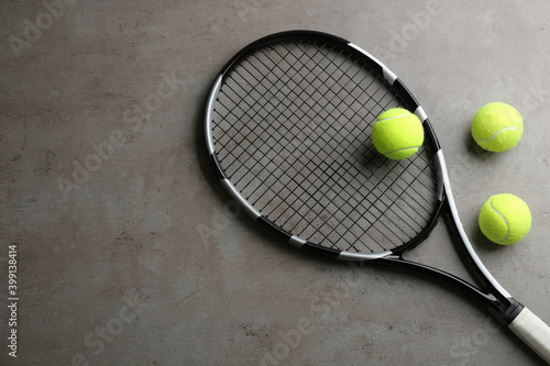Tennis racket and balls on grey table, flat lay. Space for text © New Africa