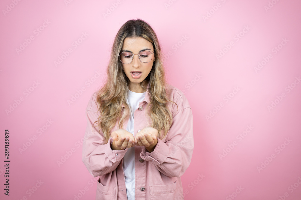 Young beautiful blonde woman with long hair standing over pink background Smiling with hands palms together receiving or giving gesture. Hold and protection Young beautiful blonde woman with long hair standing over pink background Smiling with hands palms together receiving or giving gesture. Hold and protection