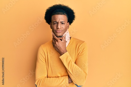 African american man with afro hair wearing cervical neck collar thinking looking tired and bored with depression problems with crossed arms. © Krakenimages.com