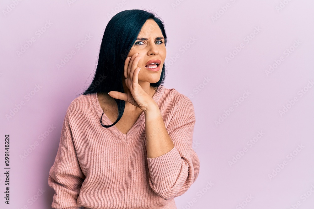 Young caucasian woman wearing casual clothes hand on mouth telling secret rumor, whispering malicious talk conversation Young caucasian woman wearing casual clothes hand on mouth telling secret rumor, whispering malicious talk conversation