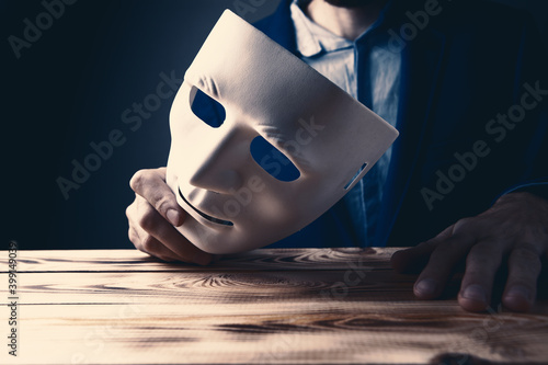 Businessman holding white mask in his hand