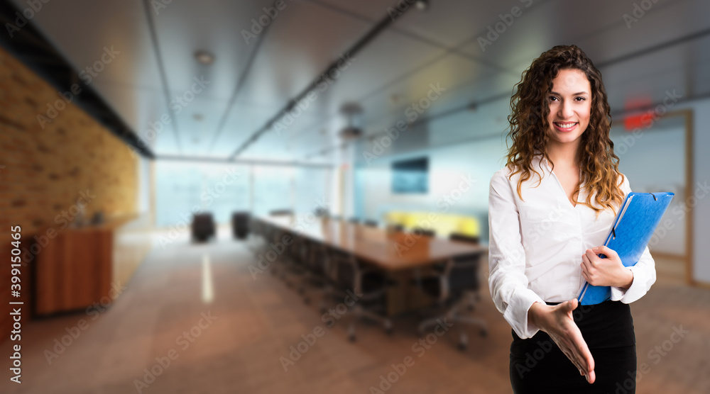 smiling businesswoman ready to shake hands in front of an office scene