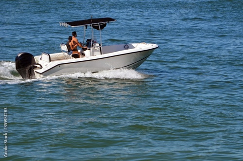 Canvas Print Young couple cruising on the Florida Intra-Coastal Waterway in a small open white sport fishing boat