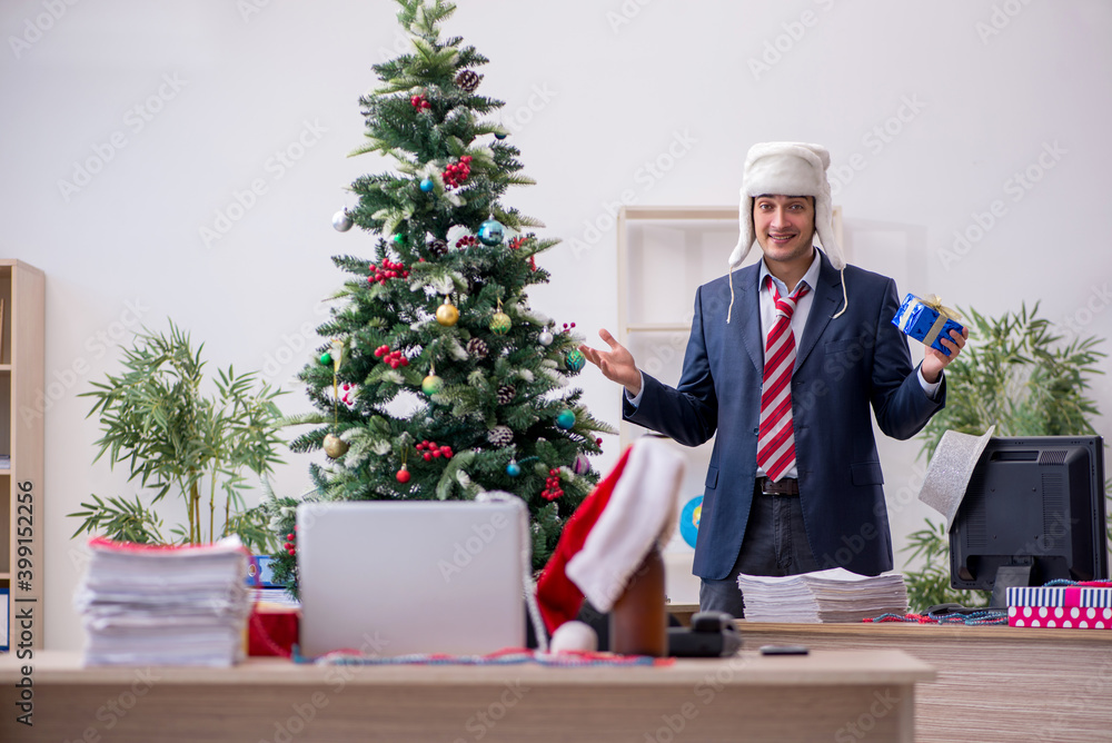 Young male employee celebrating new year in the office Young male employee celebrating new year in the office