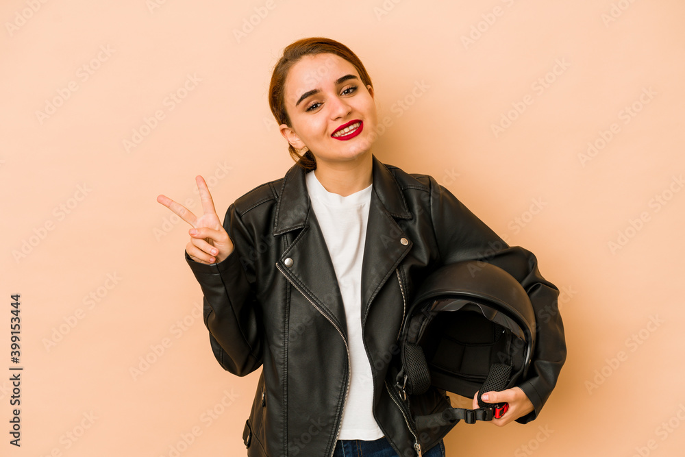 Young skinny arab gardener woman joyful and carefree showing a peace symbol with fingers. Young skinny arab gardener woman joyful and carefree showing a peace symbol with fingers.