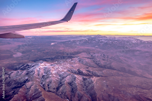 flying over rockies in airplane from salt lake city at sunset