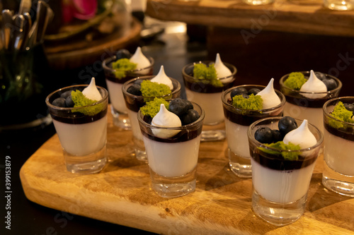 Small glasses filled with panna cotta, blueberries and a meringue
