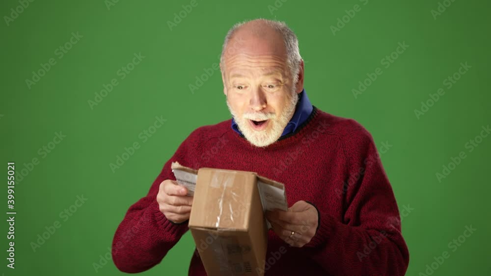 Happy male customer open parcel box smiling and surprised as light illuminates his face from inside box on green screen. Happy male customer open parcel box smiling and surprised as light illuminates his face from inside box on green screen.