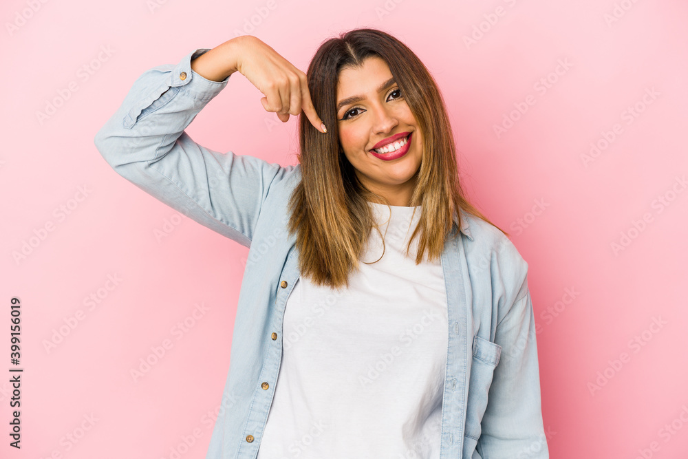 Young indian woman isolated on pink background person pointing by hand to a shirt copy space, proud and confident Young indian woman isolated on pink background person pointing by hand to a shirt copy space, proud and confident