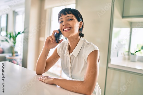 Obraz na plátně Beautiful brunette woman with short hair at home speaking on smartphone