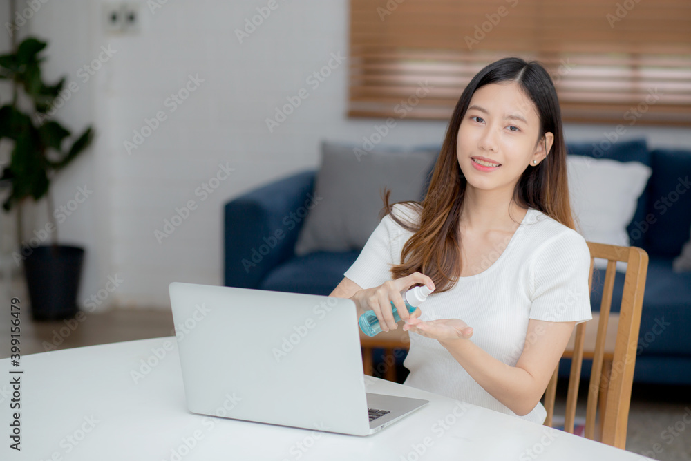Young asian woman work from home with alcohol gel or sanitizer for cleaning hand and protect coronavirus or covid-19, new normal, quarantine and social distancing, businesswoman using laptop computer. Young asian woman work from home with alcohol gel or sanitizer for cleaning hand and protect coronavirus or covid-19, new normal, quarantine and social distancing, businesswoman using laptop computer.
