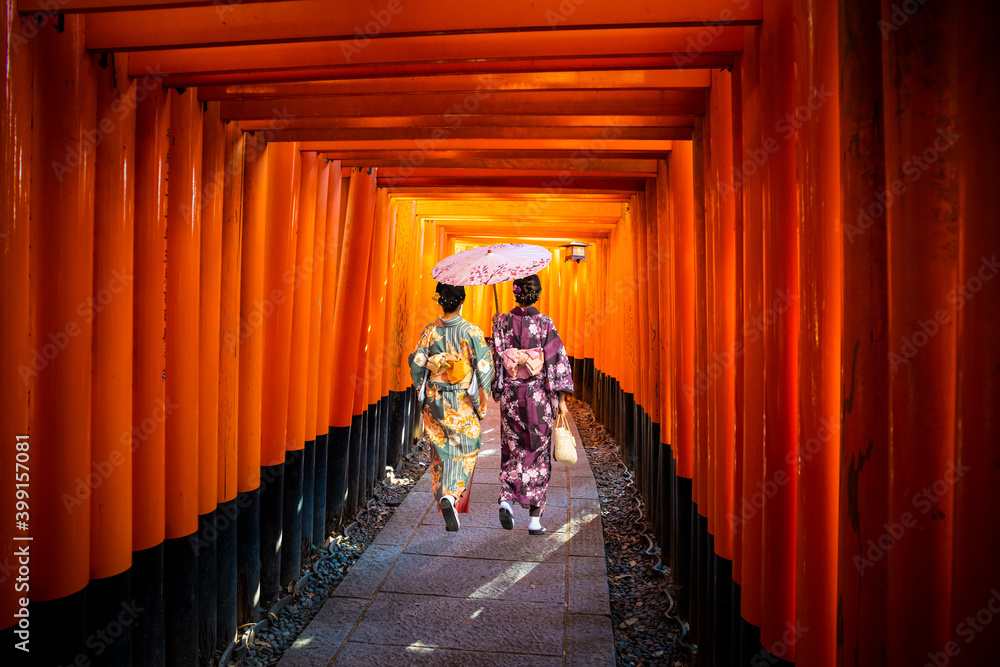 Fototapeta premium Women in traditional japanese kimonos walking at Fushimi Inari Shrine in Kyoto, Japan