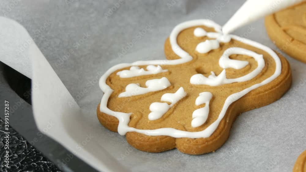 Christmas holiday gingerbread cookie. Women's hands are decorated with sweet white glaze. Cookies in the form of a beautiful bird in the home kitchen. New Year festive atmosphere Christmas holiday gingerbread cookie. Women's hands are decorated with sweet white glaze. Cookies in the form of a beautiful bird in the home kitchen. New Year festive atmosphere