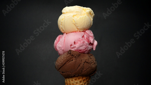 strawberry and Vanilla on top Chocolate ice cream cone isolated on black background. photo