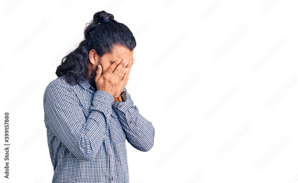 Young arab man wearing casual clothes with sad expression covering face with hands while crying. depression concept. Young arab man wearing casual clothes with sad expression covering face with hands while crying. depression concept.