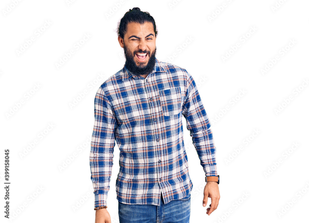 Young arab man wearing casual clothes winking looking at the camera with sexy expression, cheerful and happy face. Young arab man wearing casual clothes winking looking at the camera with sexy expression, cheerful and happy face.