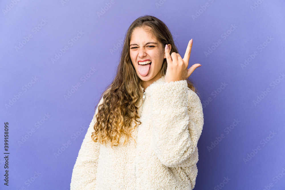 Young caucasian cute woman showing rock gesture with fingers Young caucasian cute woman showing rock gesture with fingers