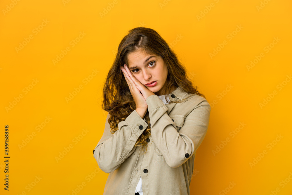 Young caucasian woman yawning showing a tired gesture covering mouth with hand. Young caucasian woman yawning showing a tired gesture covering mouth with hand.